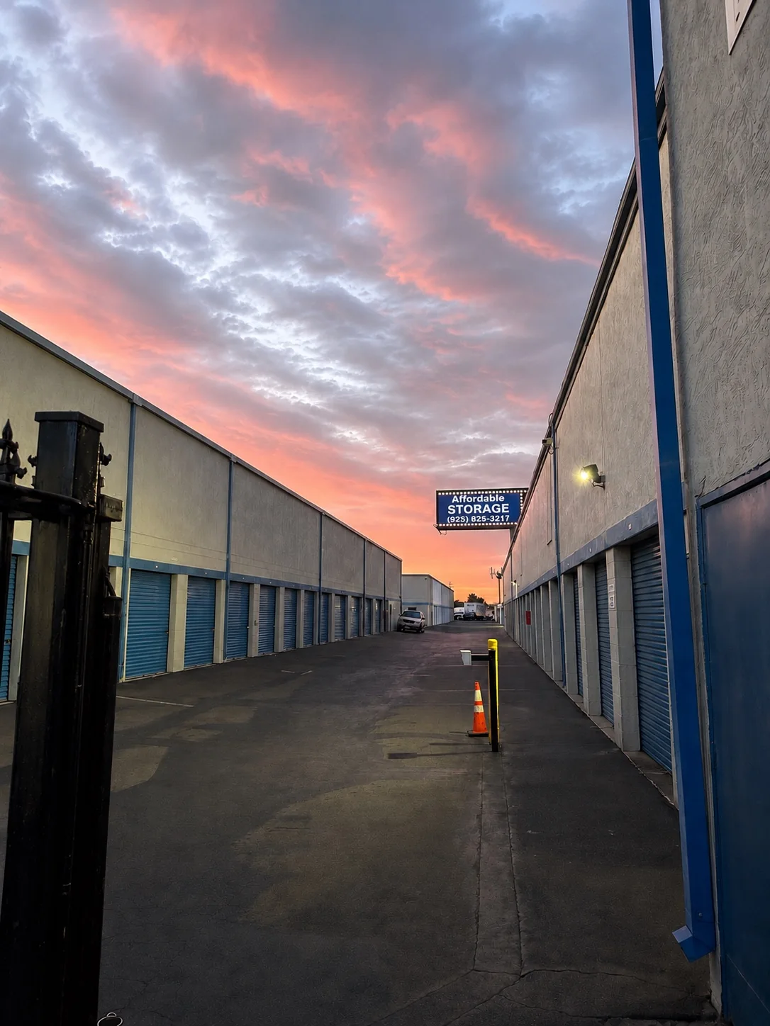 Drive-up storage units beneath a colorful sunset sky